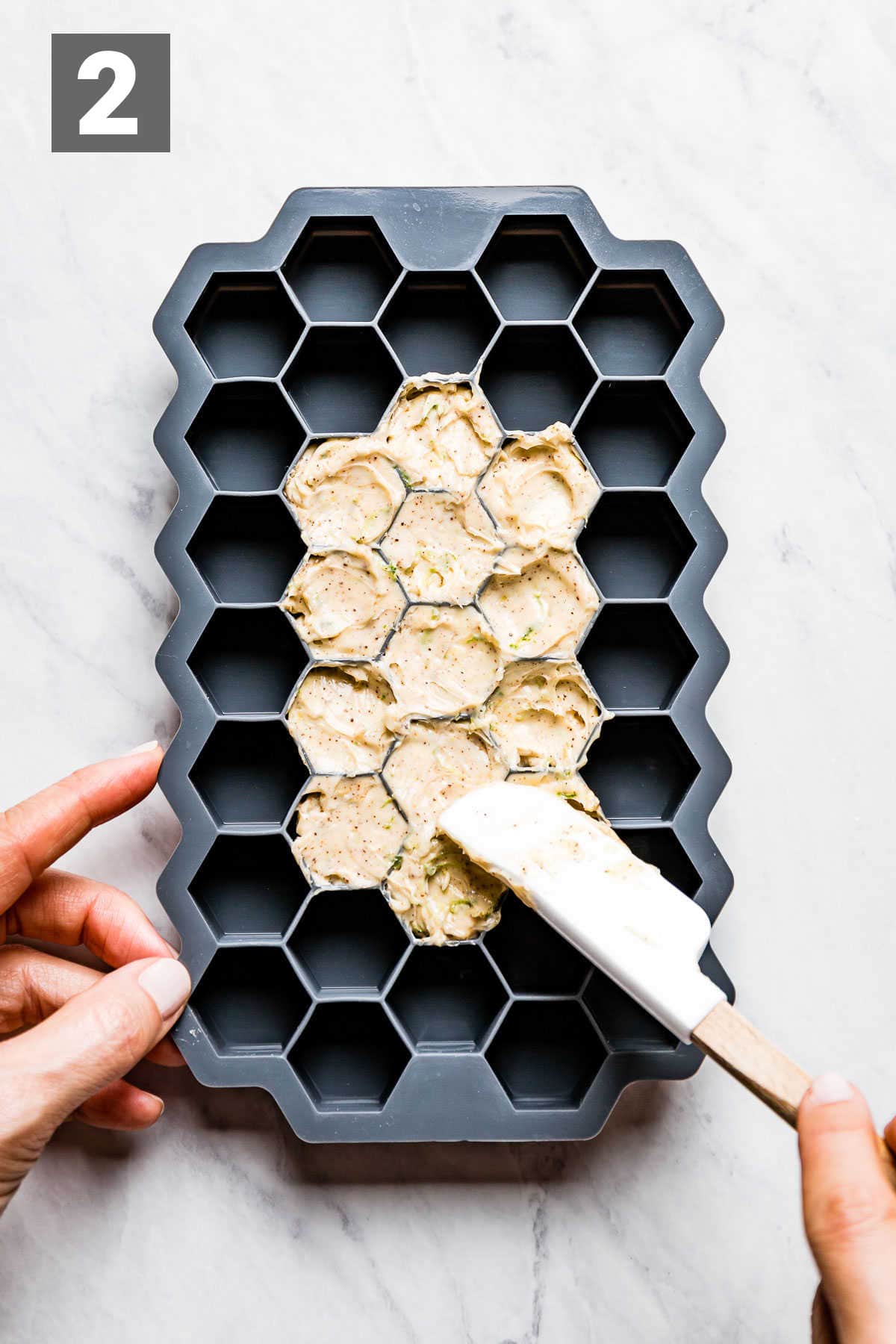 spreading the butter into the ice cube tray