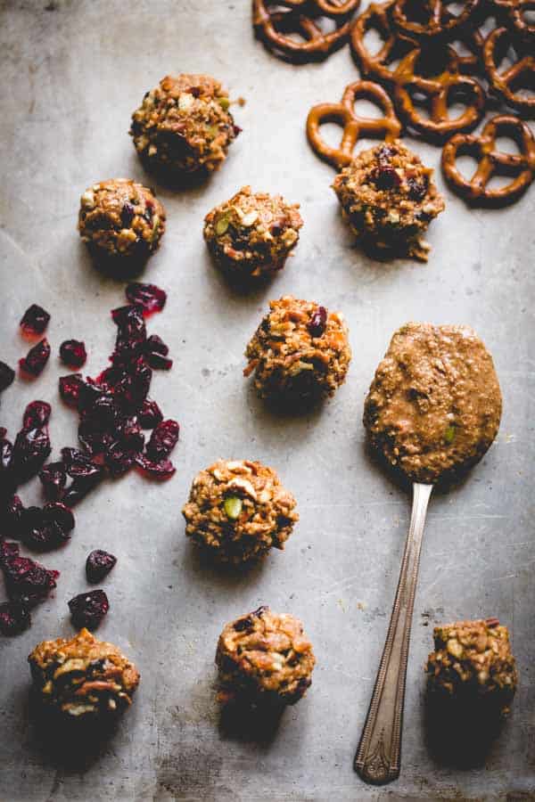 Peanut Butter Pretzel Balls on a baking sheet next to a spoon of peanut buter