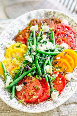 tomatoes, green beans and goat cheese on a large oval platter