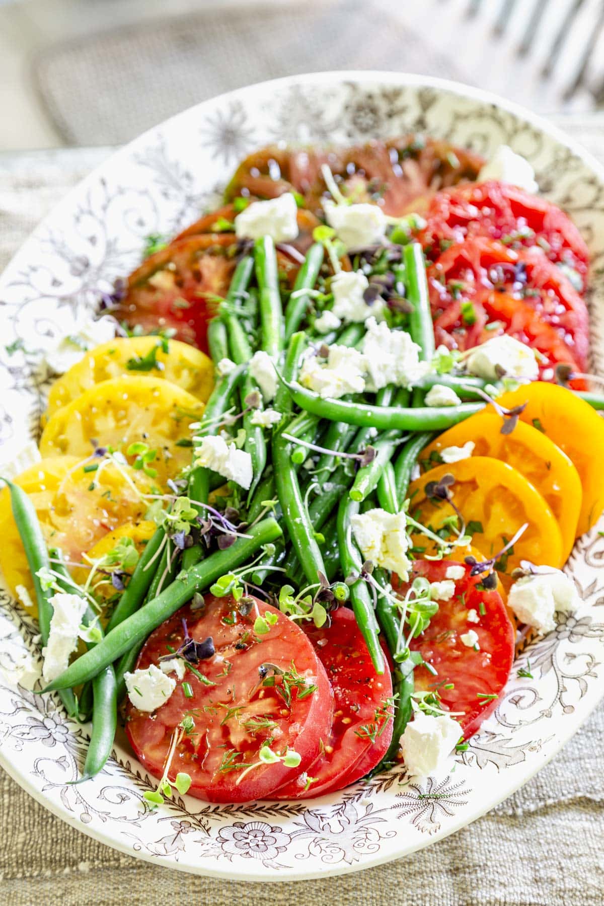 tomatoes, green beans and goat cheese on a large oval platter