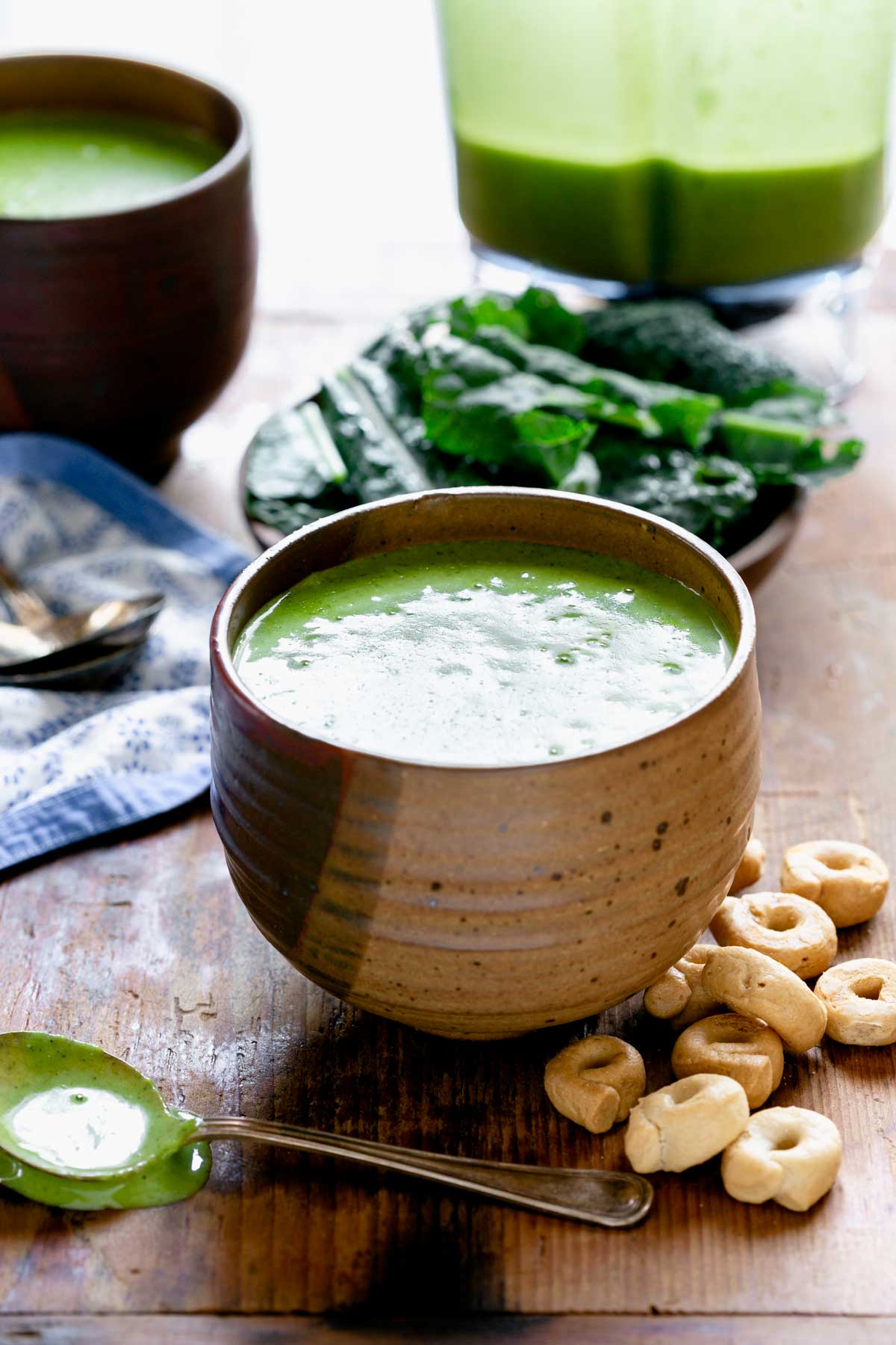 the kale soup in a hand made bowl with Italian crackers on a wooden board