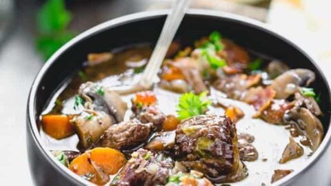 a close up from 3/4 side angle of a black bowl with beef burgundy