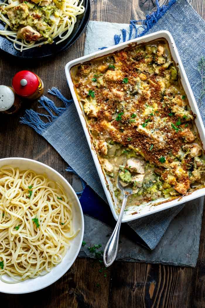 overhead tablescape with a casserole of chicken divan, and a bowl of pasta