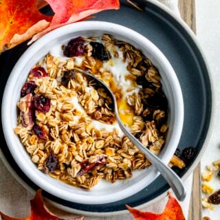 a closeup of the maple granola in a bowl with yogurt and a spoon