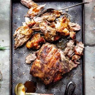 Slow roasted pork shoulder on a metal baking sheet with a hex pattern