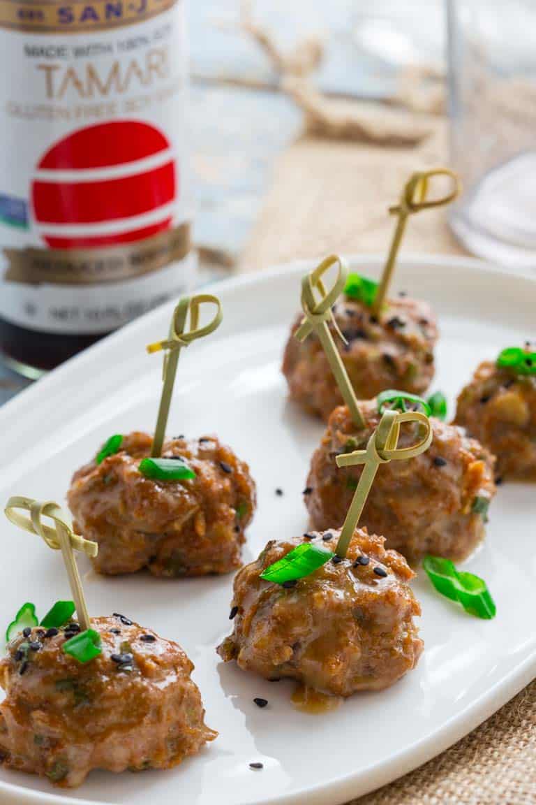 tamari turkey meatballs with maple tahini glaze on a serving platter with toothpicks.