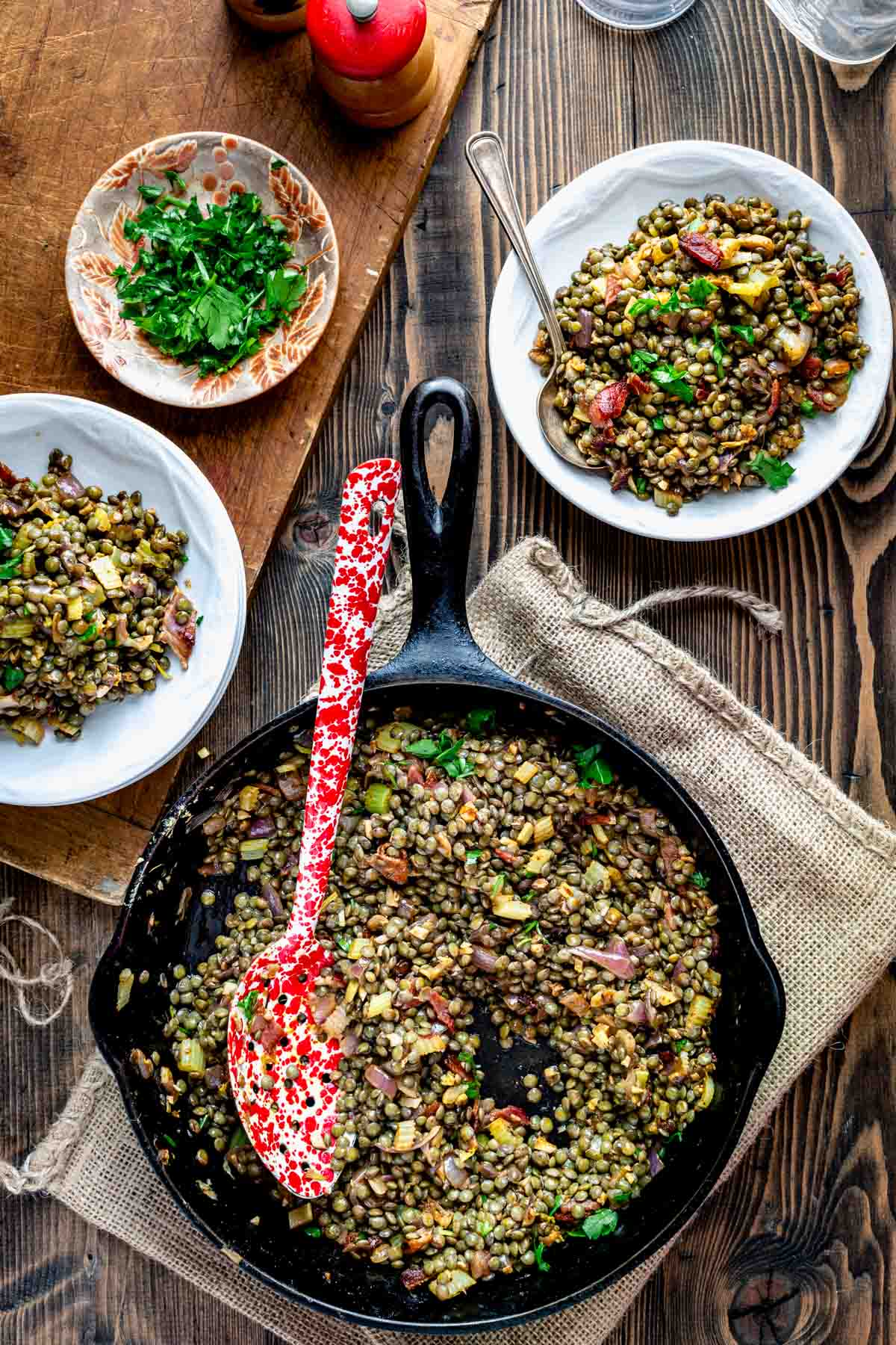 a skillet and two dishes with lentils
