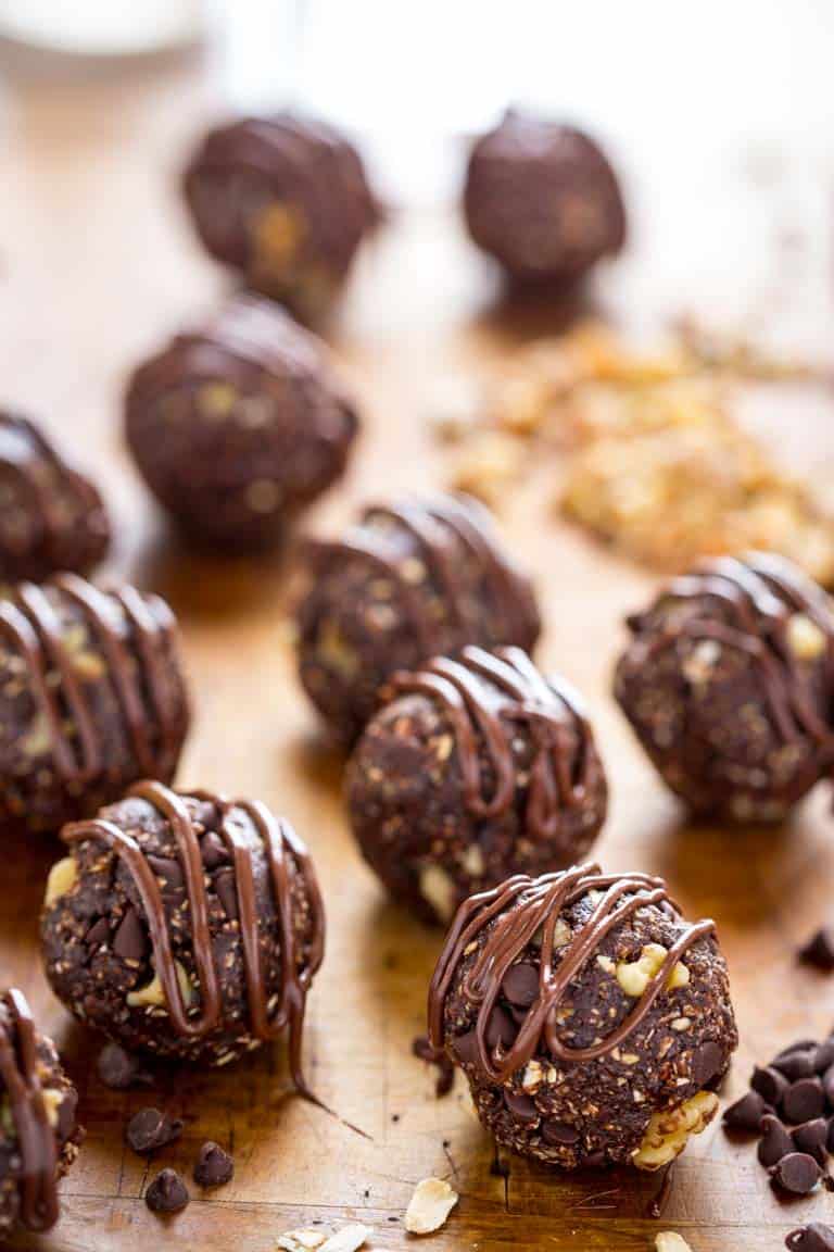 Dark chocolate walnut vegan energy balls with chocolate drizzled over top.