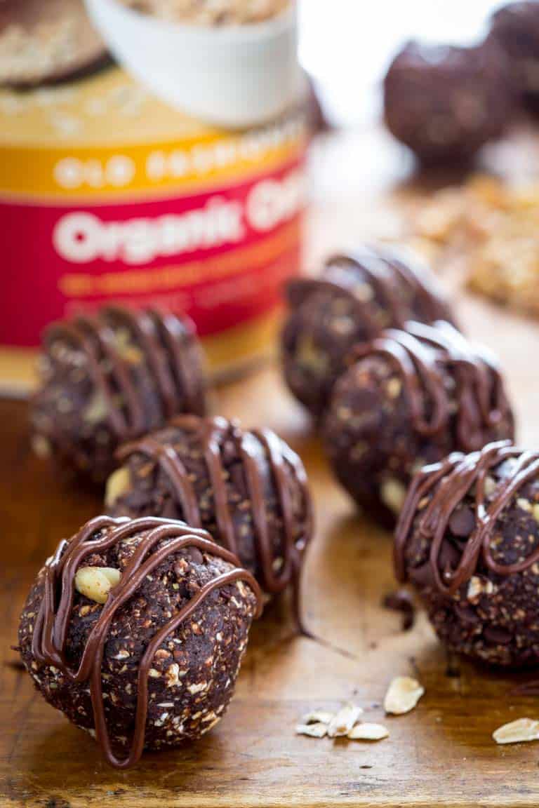 Dark chocolate walnut vegan energy balls next to oats.