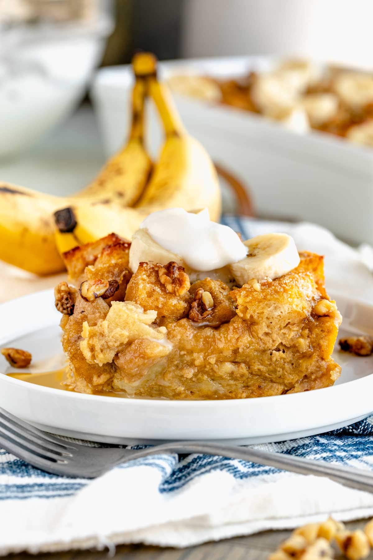 a serving of bread pudding on a plate with whipped cream on top