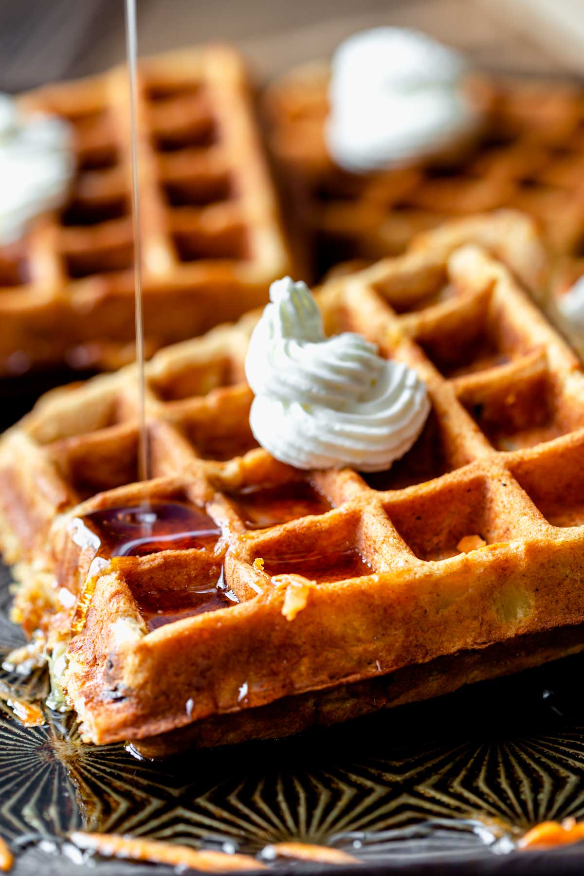 close-up of the waffles with syrup being poured over them