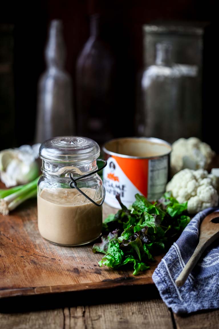 Maple Tahini Dressing in a jar on a cutting board