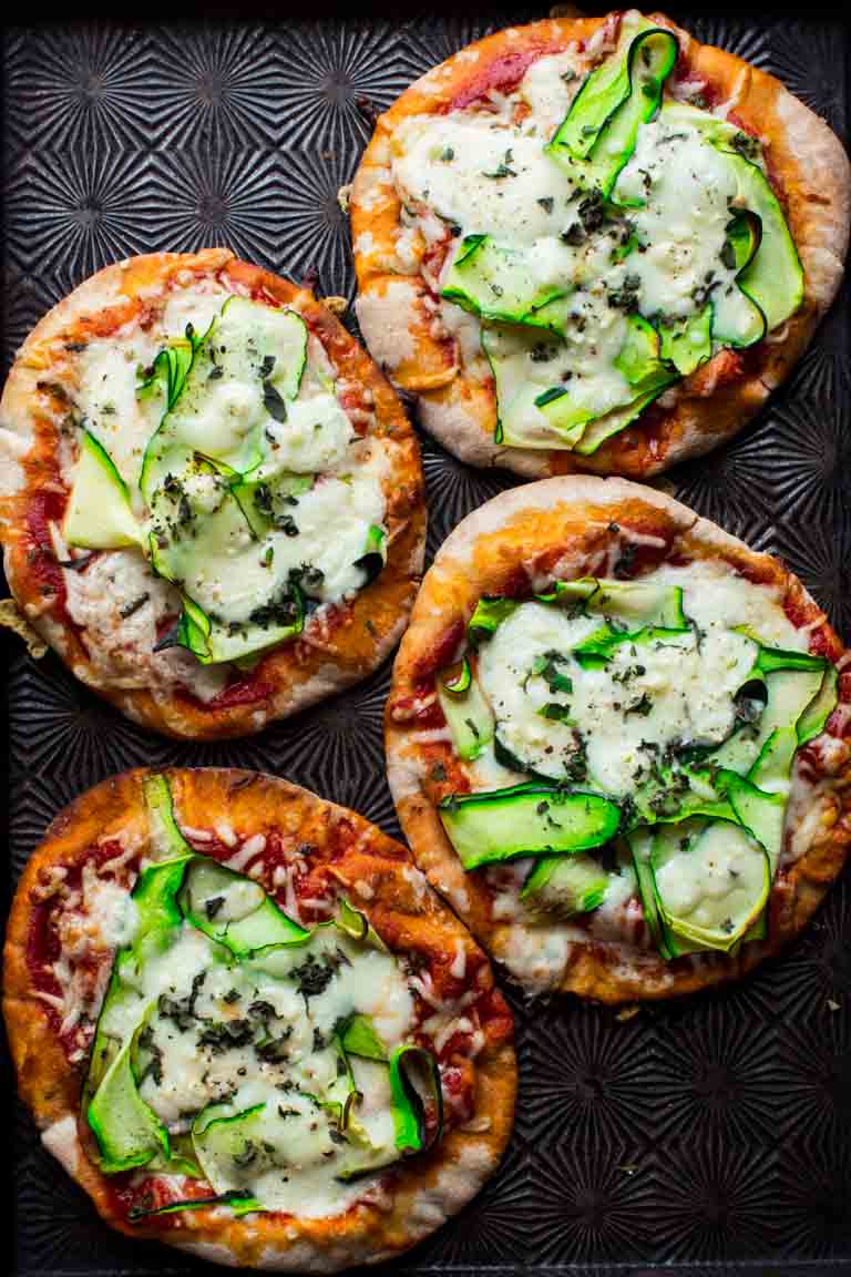 overhead shot of 4 mini zucchini pita pizzas