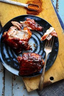a blue plate with two chicken thighs on it