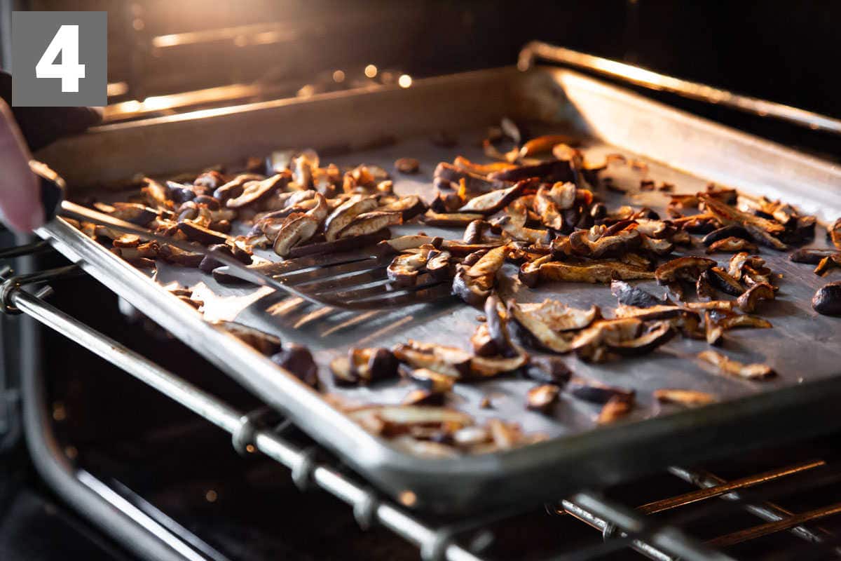 Sliced and seasoned mushrooms cooking on a tray in the oven