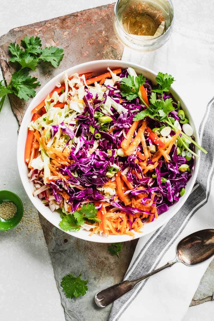 Close-up of coleslaw in a bowl from overhead. Garnished with cilantro.