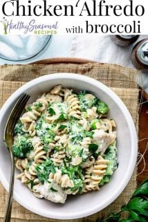 a close up view of a serving of chicken alfredo with broccoli