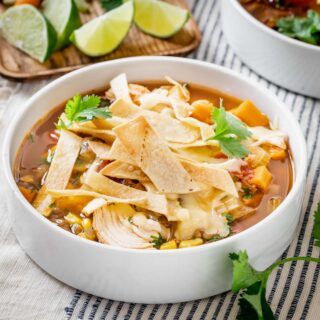 close up of bowl of soup on a white and blue cloth