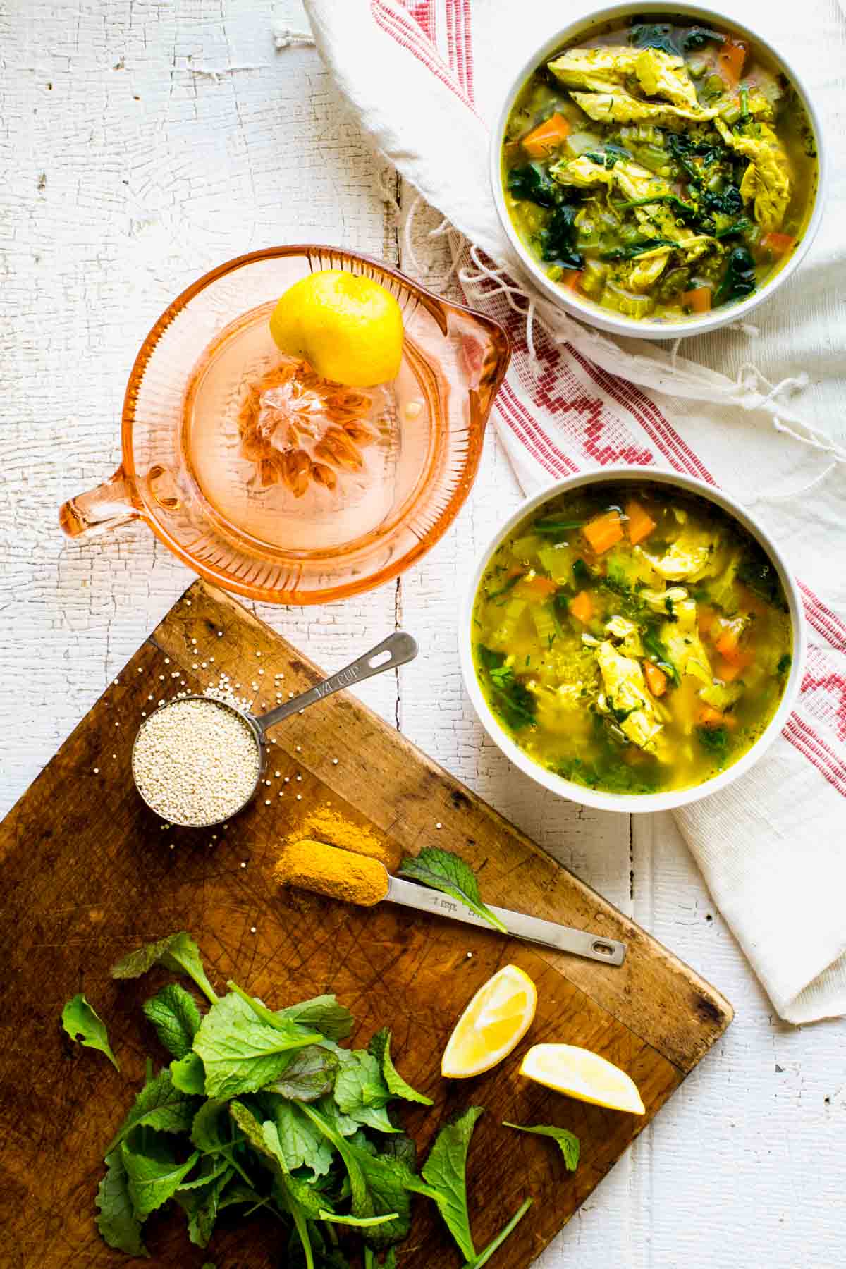 some of the ingredients for the recipe on a white table with two bowls of soup