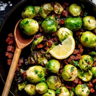 closeup of the brussels in a black skillet with a wooden spoon