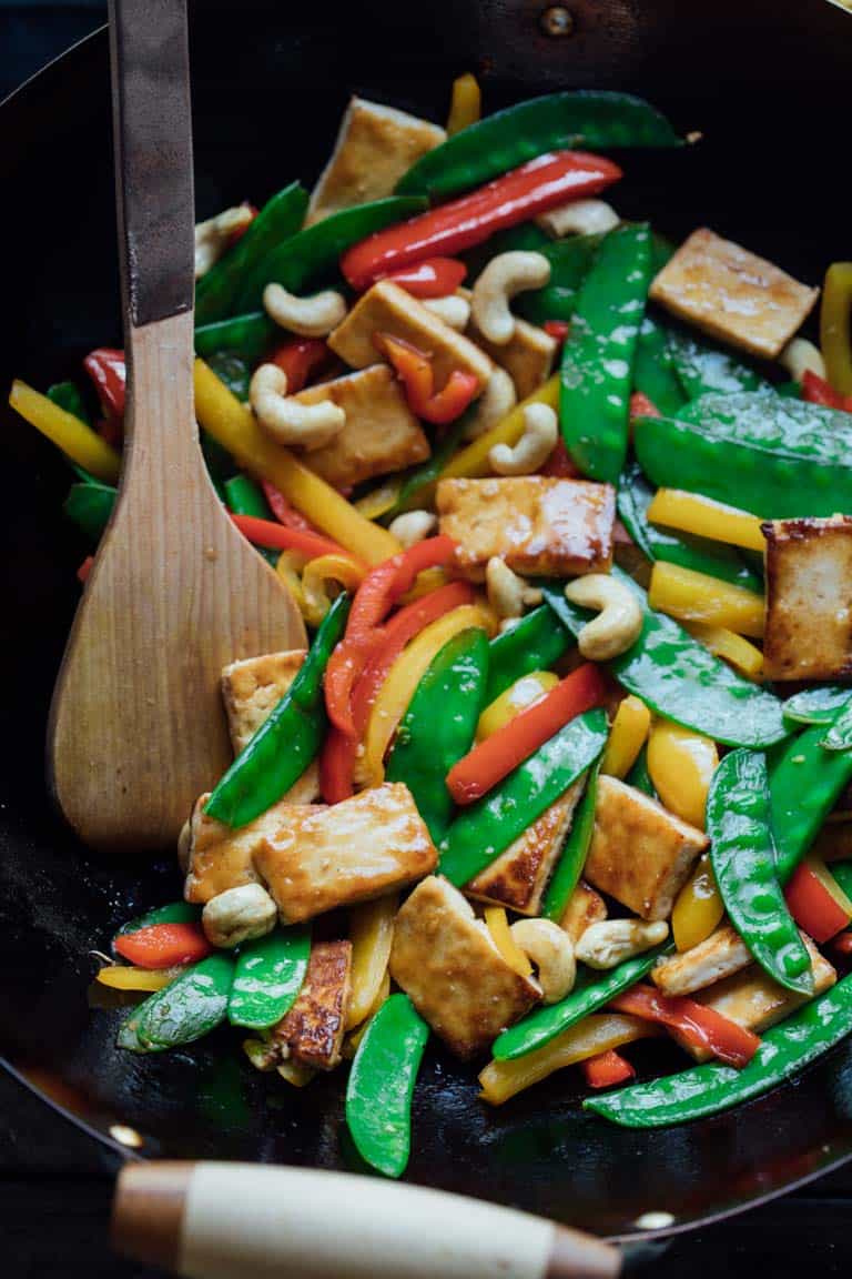 veggie stir fry with tofu and cashews in a wok