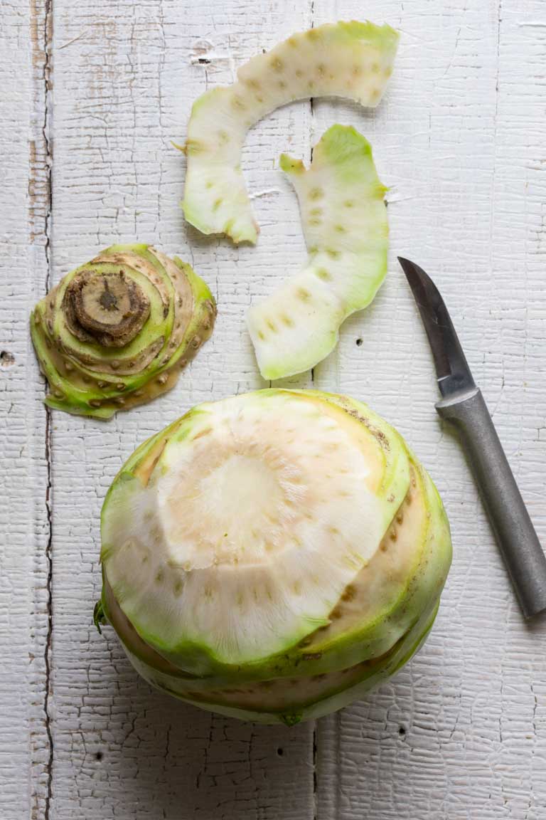 a partially peeled green kohlrabi bulb
