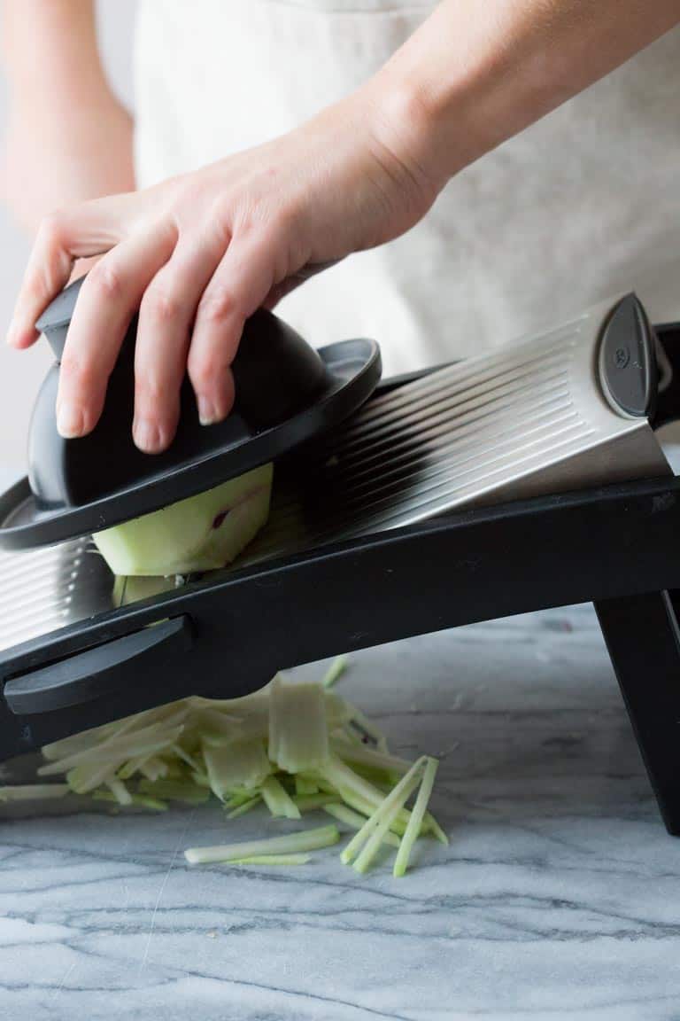 cutting kohlrabi into julienne strips with a mandolin