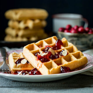 the cranberry almond waffles on a plate from the side