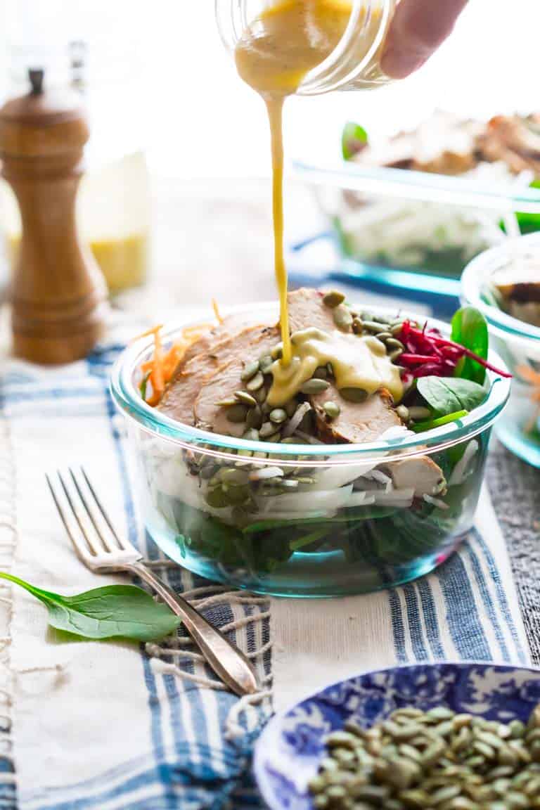 Pouring dressing over a salad in tupperware