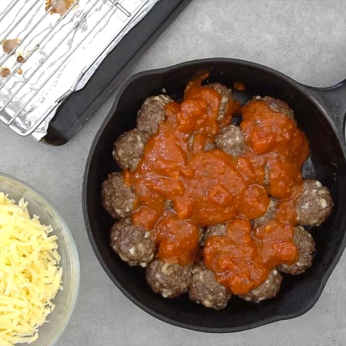 Top the baked meatballs with sauce.