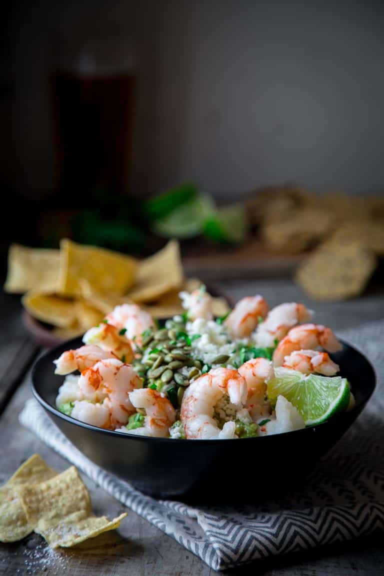 Fancy Guacamole Shrimp Cocktail- Facncy up classic guac by topping it with Cotija Cheese, Pepitas and cooked shrump for a grain-free and super festive party appetizer for the superbowl or cinco de mayo