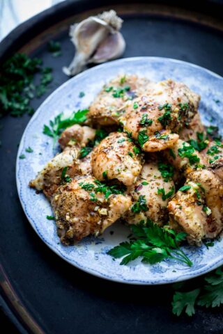 a blue plate with balsamic chicken thighs on it