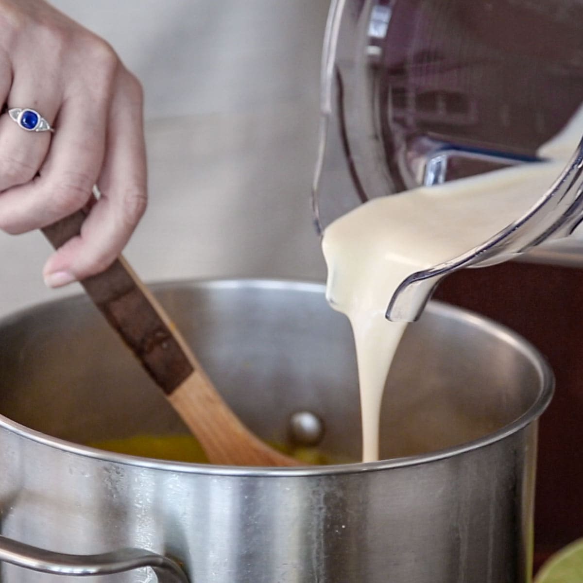 pouring the pureed coconut milk into the soup