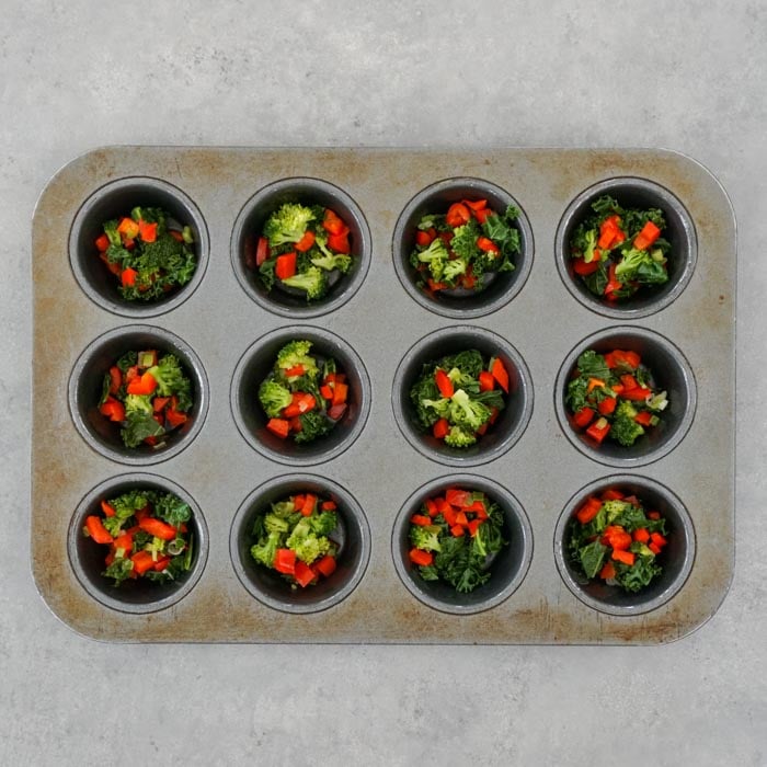 divide the veggies among the wells of the muffin tin