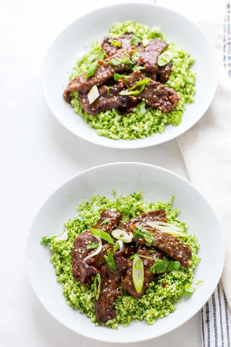 mongolian beef over a bed of riced broccoli in a grain free bowl