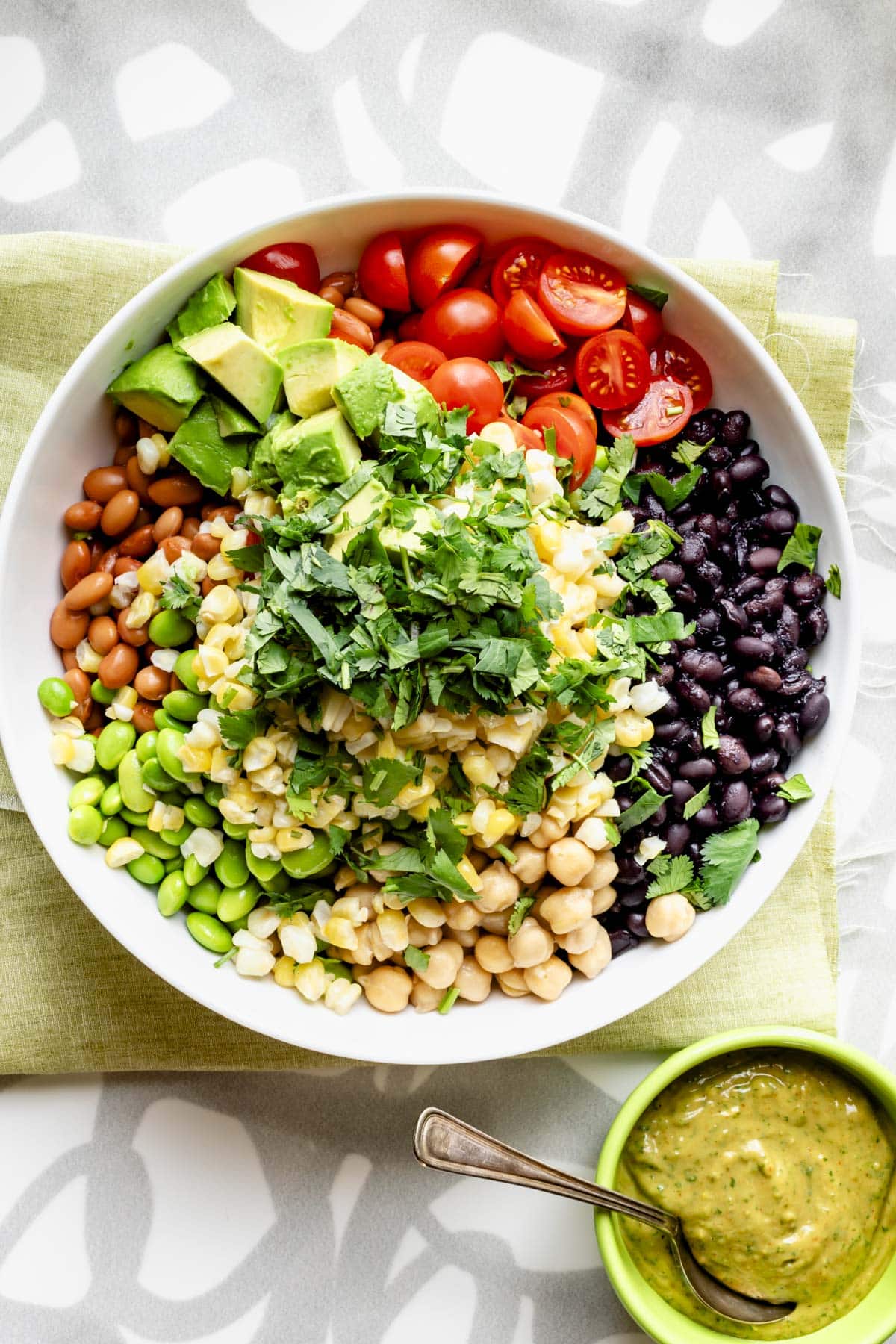 the salad before the dressing is stirred into it, all of the components are arranged in separate quadrants of the bowl in a colorful kaleidoscope