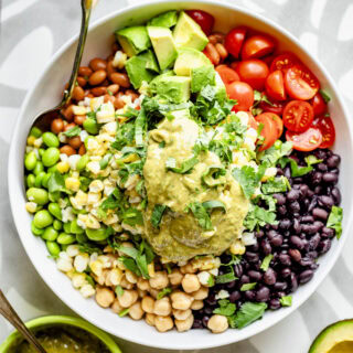 the salad with the dressing dolloped on top of it with all of the components arranged in separate quadrants of the bowl like a kaleidoscope