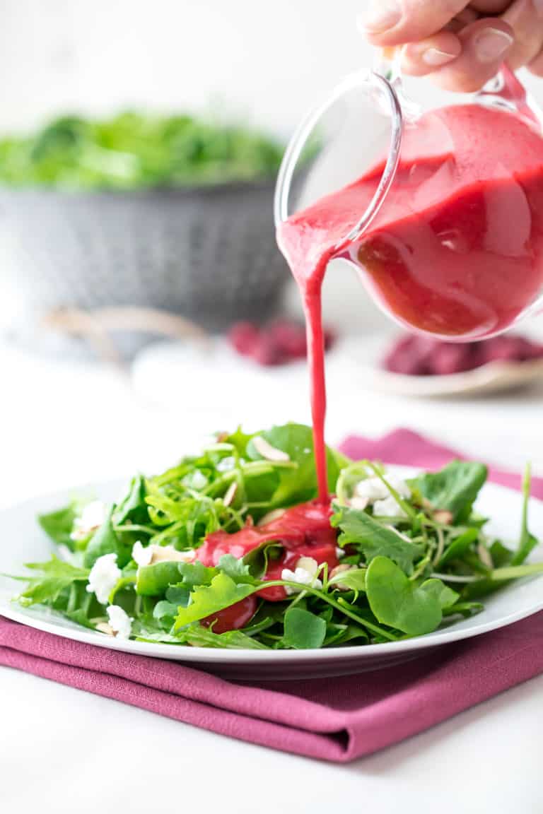 Raspberry Salad Dressing Recipe being poured over salad