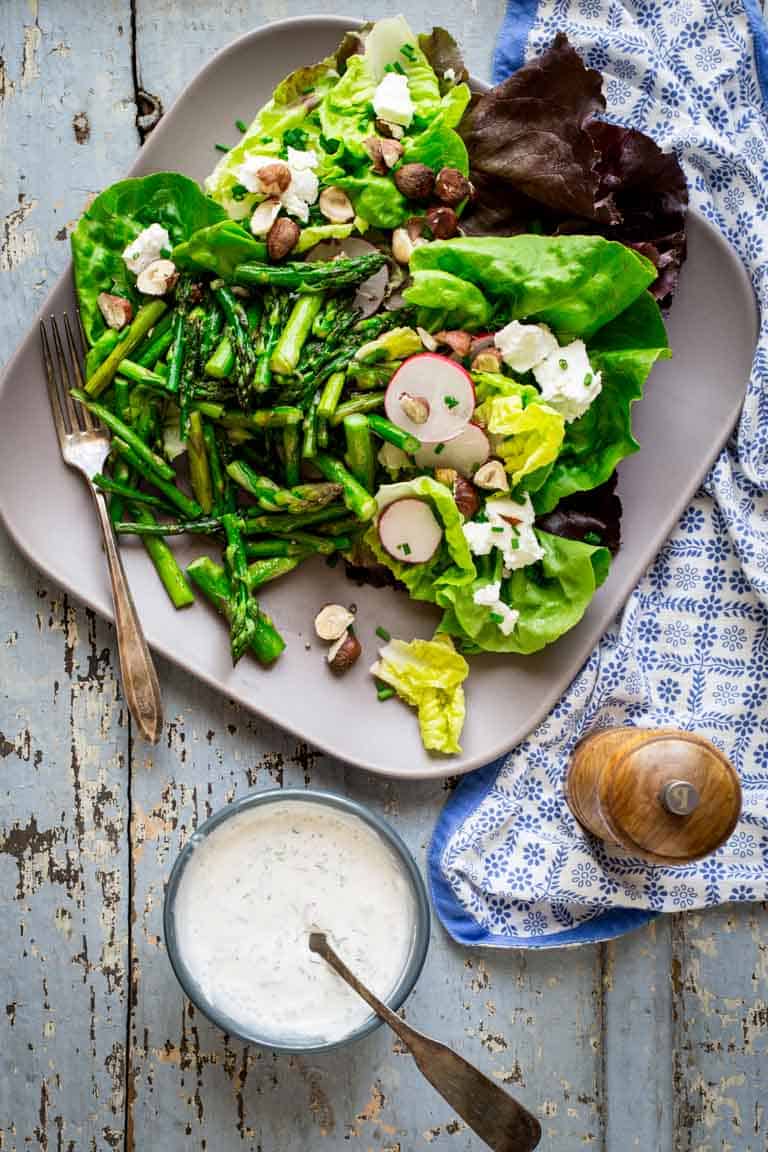 Roasted asparagus, chopped hazelnuts and fresh goat cheese bring staying power to these hearty spring entrée salads. They’re naturally gluten-free and vegetarian. Healthy Seasonal Recipes by Katie Webster | #glutenfree #vegetarian #entreesalad #asparagus #goatcheese