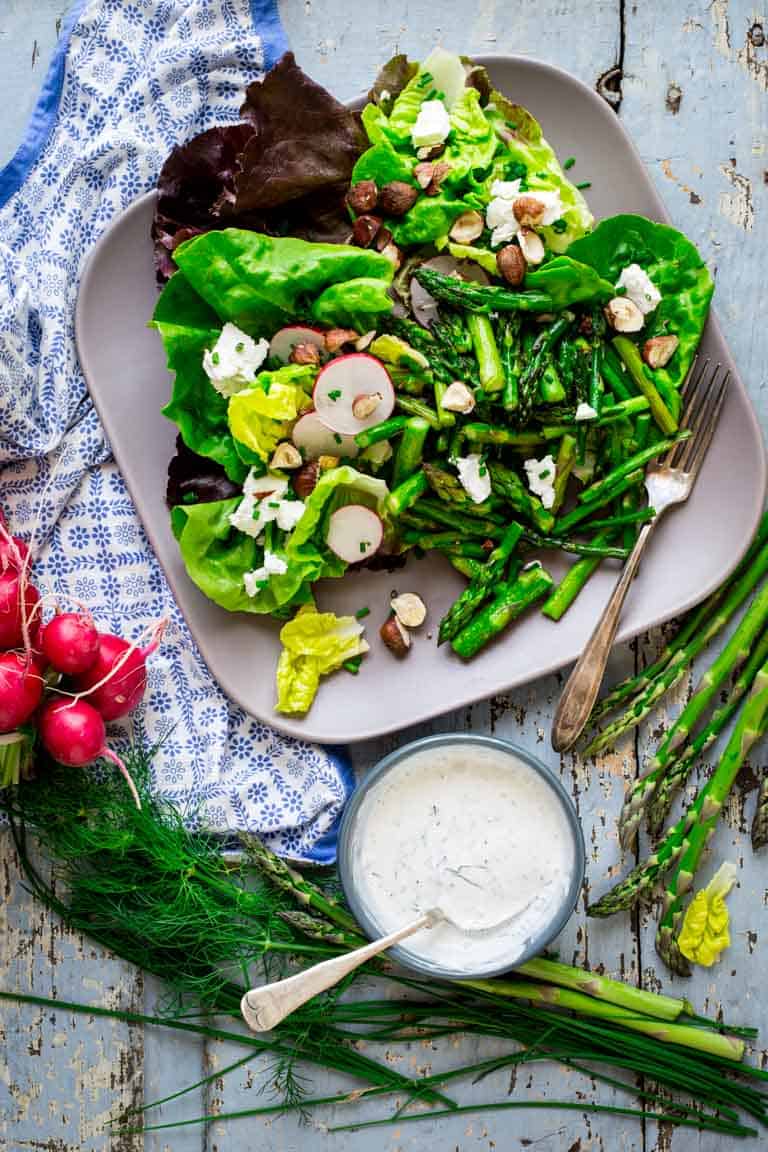 Roasted asparagus, chopped hazelnuts and fresh goat cheese bring staying power to these hearty spring entrée salads. They’re naturally gluten-free and vegetarian. Healthy Seasonal Recipes by Katie Webster | #glutenfree #vegetarian #entreesalad #asparagus #goatcheese