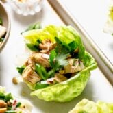 a side view of a lettuce wrap with peanuts and herbs