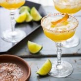 These smoky, tart and sweet Mescal Margaritas, made with Cuantro, freshly squeezed lime and orange juice have a salted rim with a surprising ingredient! #mescal #margarita #cocktail #cincodemayo #vegan #lime #mexican