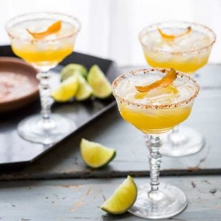 These smoky, tart and sweet Mescal Margaritas, made with Cuantro, freshly squeezed lime and orange juice have a salted rim with a surprising ingredient! #mescal #margarita #cocktail #cincodemayo #vegan #lime #mexican