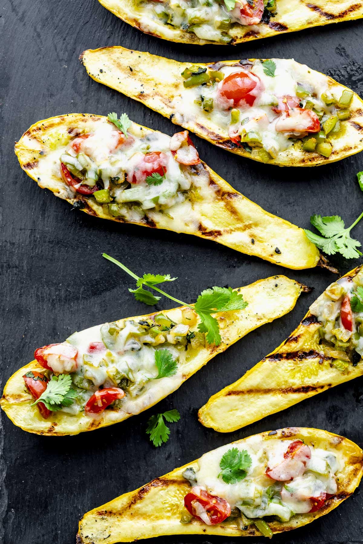 the grilled stuffed summer squash on a black slate