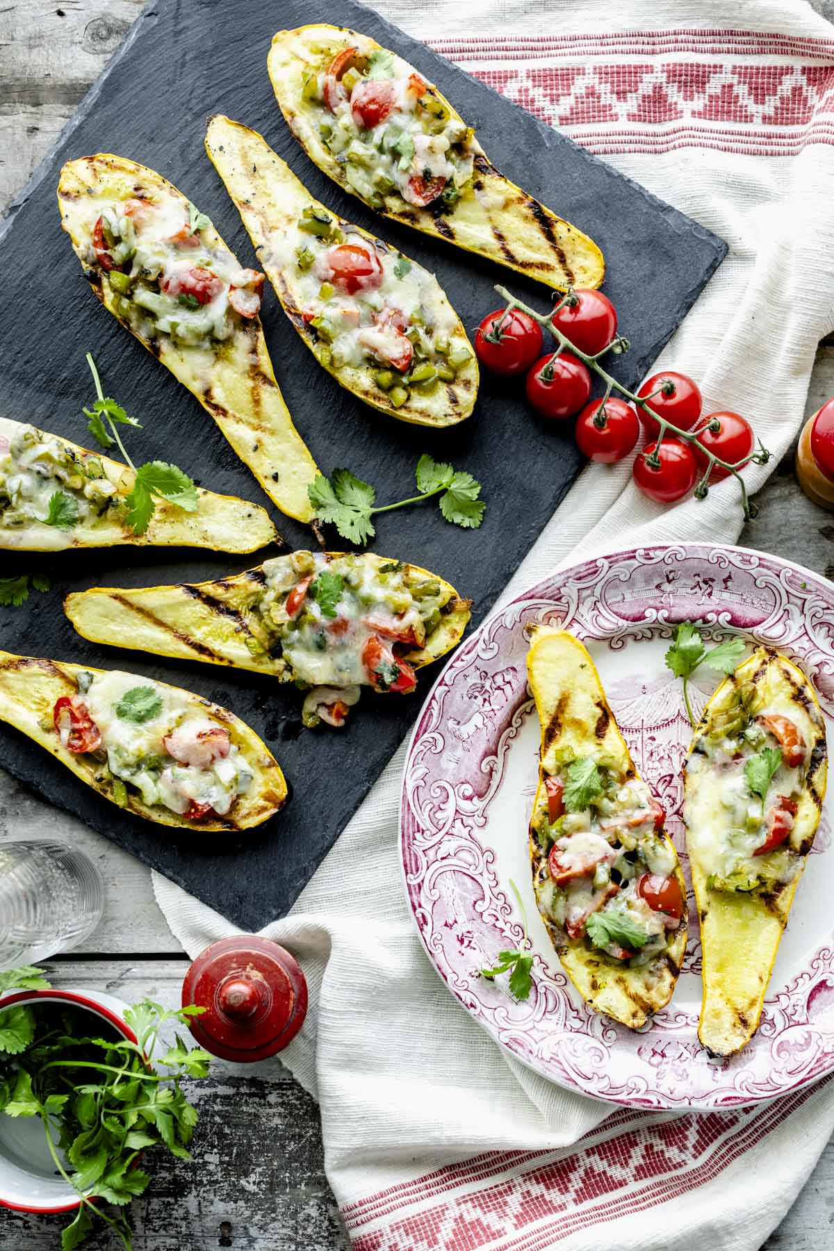 the stuffed summer squash with grill marks on a black slate board and red and white decorated plate
