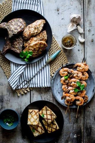 garlic marinade in a jar on a cutting board with grilled chicken