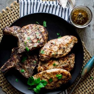 A platter of garlic marinated pork and chicken on a woven placemat