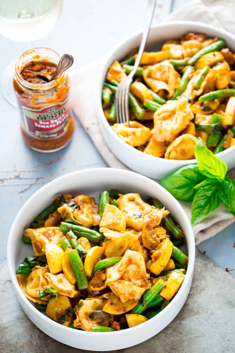 two bowls of tortellini with green beans