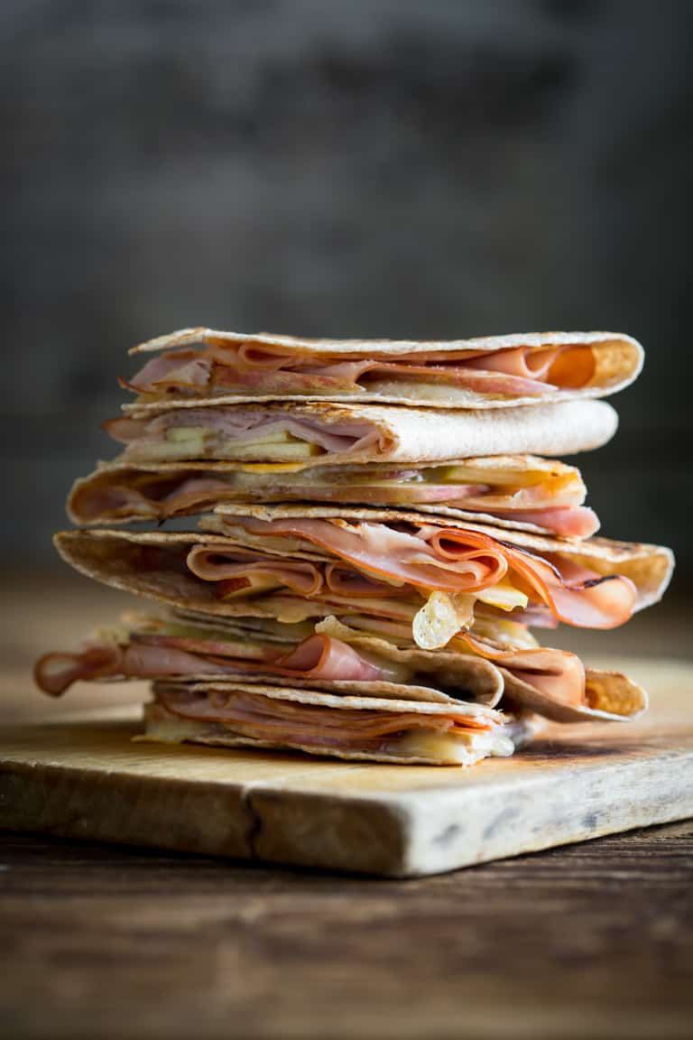 Apple Ham and Cheddar Quesadillas stacked on a cutting board