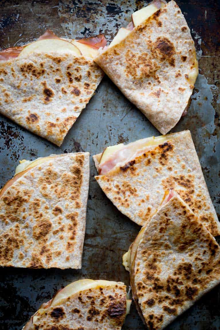 Apple Ham and Cheddar Quesadillas on a rimmed baking sheet